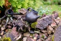 Black clay jug and old wooden barrel on stone pile Royalty Free Stock Photo