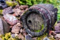 Black clay jug and old wooden barrel on stone pile Royalty Free Stock Photo