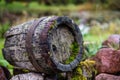 Black clay jug and old wooden barrel on stone pile Royalty Free Stock Photo