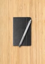 Black closed notebook with a pen on wooden background Royalty Free Stock Photo