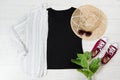 Black closeup t shirt mock up flat lay on white wooden background. Top view and copy space. Mockup t-shirt and summertime. Royalty Free Stock Photo