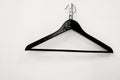 Black clothes hanger hanging on a white wall background Royalty Free Stock Photo