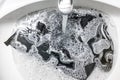 Black laundry lies in sink with foam