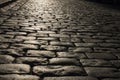 Black cobbled stone road background with reflection of light seen on the road. Black or dark grey stone pavement texture. Royalty Free Stock Photo