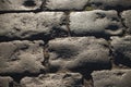 Black cobbled stone road background with reflection of light seen on the road. Black or dark grey stone pavement texture. Royalty Free Stock Photo