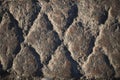 Black cobbled stone road background with reflection of light seen on the road. Black or dark grey stone pavement texture.