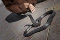 Black cobra snake with snake charmer detail in the background at Djemaa el Fna in Marrakech, Morocco Royalty Free Stock Photo