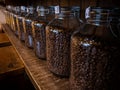 Black coffee beans glass jar packaging package on wood stand at caffe shop Royalty Free Stock Photo