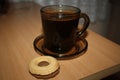 Black coffee in a black glassy cup with biscuit Royalty Free Stock Photo