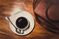 Black coffee and a camera on a wooden table