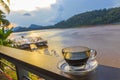 Black coffee crema in transparent cup while colorful sunset Laos
