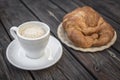 Black coffee and crispy croissant on a wooden table Royalty Free Stock Photo
