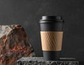 Black Coffee Cup with Brown Sleeve on Speckled Stone with Dark Background Royalty Free Stock Photo