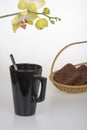 Black coffee cup, chocolate muffins and yellow orchid Royalty Free Stock Photo