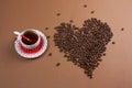 black coffee cup and heart made from coffee beans brown background Royalty Free Stock Photo