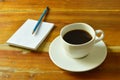 black coffee cup with note book and pencil on table Royalty Free Stock Photo