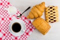 Coffee in cup, spoon, milk on napkin, different pastry