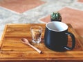 Black coffee cup with wooden spoon , green cactus , brown sugars