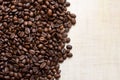 Black coffee grains lie on light wooden table, background image. place for text Royalty Free Stock Photo