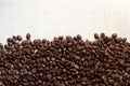 Black coffee grains lie on light wooden table, background image. place for text Royalty Free Stock Photo