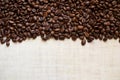 Black coffee grains lie on light wooden table, background image. Royalty Free Stock Photo