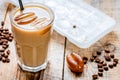 Coffee ice cubes and beans with latte on wooden desk background Royalty Free Stock Photo