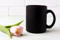 Black coffee mug mockup with pink tulip Royalty Free Stock Photo