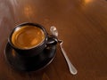 Black coffee mugs and spoon are placed on brown wood Royalty Free Stock Photo