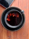 black coffee plus ginger in black cup on brown table Royalty Free Stock Photo