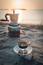 Black coffee ready to drink from mug on the beach outdoor picnic