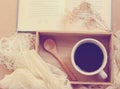 Black coffee and spoon on wooden tray with book, retro filter