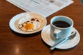 Black coffee on the table with fried egg and business newspaper Royalty Free Stock Photo