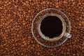 Black coffee transparent full glass cup on beans