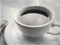 Black coffee in white ceramic cup and saucer in a cafe under natural light.