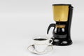 Black coffee in a white ceramic mug with gold rim and saucer. Blur Black and gold espresso machine  and Coffee cup storage on Royalty Free Stock Photo