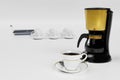 Black coffee in a white ceramic mug with gold rim and saucer. Black and gold espresso machine on white background and white Royalty Free Stock Photo