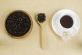 Black coffee in white cup with coffee beans in wood plate