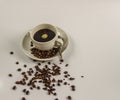 Black coffee in a white cup on saucer with spoon and spilled coffee beans Royalty Free Stock Photo