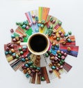 Black coffee in white cup on taster`s flavor wheel. Multi color pearl coffee beans scattered around. Top view