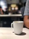 Black coffee in white cup on the wooden table with cafe light. Copy space