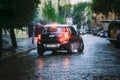 Black Color Car Mini Cooper Countryman Goes In The Rain On The Street Of The European City. Royalty Free Stock Photo