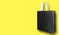 Black color fabric Bag on yellow background Royalty Free Stock Photo