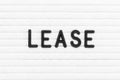 Black letter in word lease on white felt board background