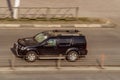 Black color Nissan Pathfinder r51 in fast motion on city street. speeding in the city is not permissible Royalty Free Stock Photo