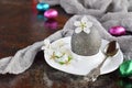 Black colored egg and flowers on clay plate. Happy Easter card. Holidays breakfast concept. Festive table place setting decoration Royalty Free Stock Photo