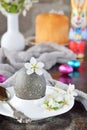 Black colored egg and flowers on clay plate. Happy Easter card. Holidays breakfast concept. Festive table place setting decoration Royalty Free Stock Photo