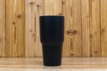 Black colour stainless steel tumbler or cold and hot storage cup on wood Royalty Free Stock Photo