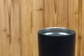 Black colour stainless steel tumbler or cold and hot storage cup on wood Royalty Free Stock Photo