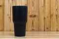 Black colour stainless steel tumbler or cold and hot storage cup on wood Royalty Free Stock Photo