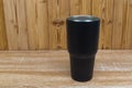 Black colour stainless steel tumbler or cold and hot storage cup on wood Royalty Free Stock Photo